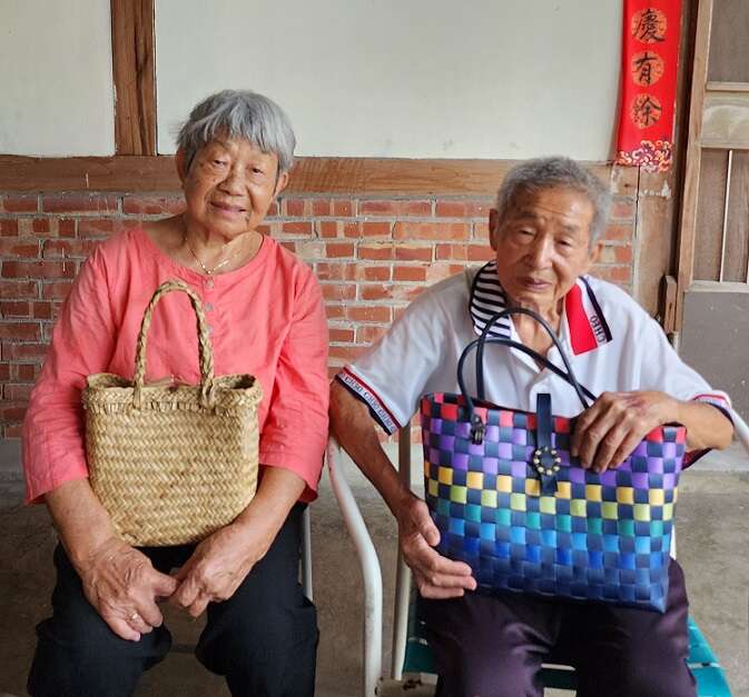 周寶鳳與先生王主玉合影，兩人手中的提包見證不同時期茄芷袋素材演變。（鄭佩雯拍攝）