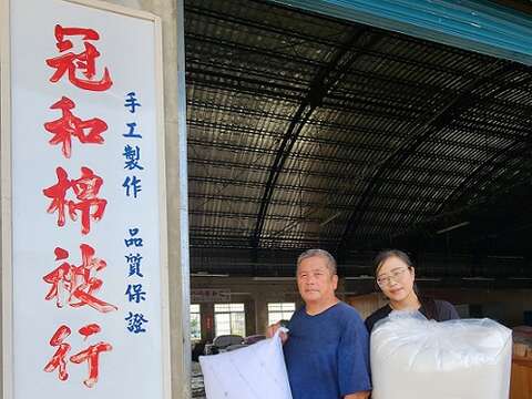坚持传承手工制被职人精神与技艺的蔡顺龙(左)、蔡雯雅(右)父女。蔡顺龙手中是隐藏版木棉花枕头,Q弹紮实。(郑佩雯拍摄)
