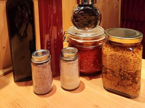 丮硠‧玛那制作的树葡萄酒、台湾紫苏气泡饮、发酵乾辣椒、发酵辣椒酱、米麴豆腐乳(後排由左到右)。前排则是用来增添食物风味的紫苏盐、紫苏盐混橘皮盐。(郑佩雯拍摄)