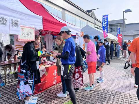 台南观光推广摊位提供特色食品试吃,吸引日本跑者及民众参与。