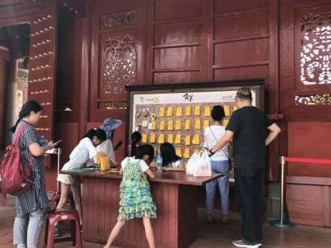 Worshiper who is writing on paper to pray for exam success