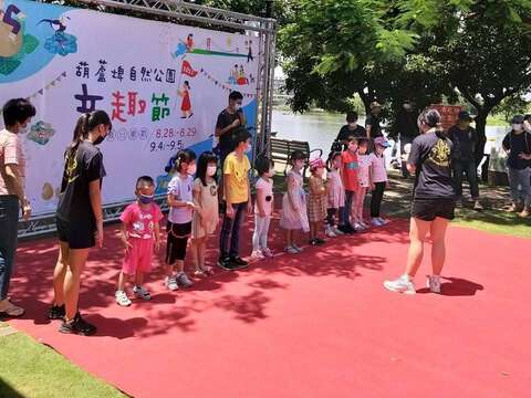 参加葫芦埤童趣节的小朋友在台上排队领奖品