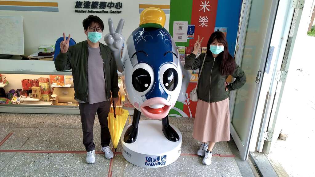 游客开心与鱼头君合照