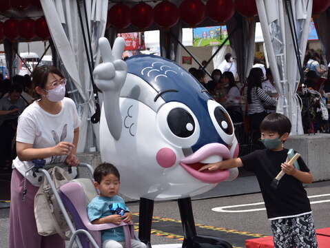 鱼头君受到当地民众欢迎许多父母带小孩拍照